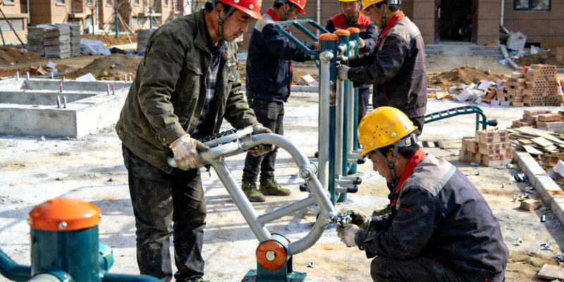 社区体育设施建设现场 - 工人在安装健身器材