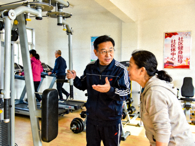 社区体育组织者张主任 - 在社区体育中心指导居民使用健身器材