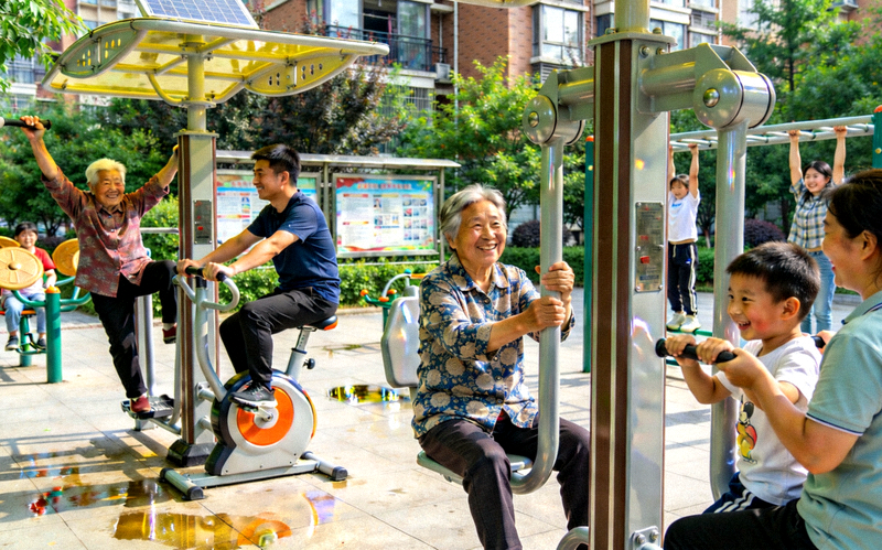 社区居民在崭新的健身器材上锻炼，笑容满面