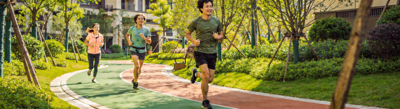 生态融合型社区健身步道 - 居民在绿树环绕的塑胶步道上跑步