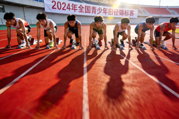 2024年全国青少年田径锦标赛男子100米决赛起跑瞬间，八名年轻运动员在起跑器上蓄势待发