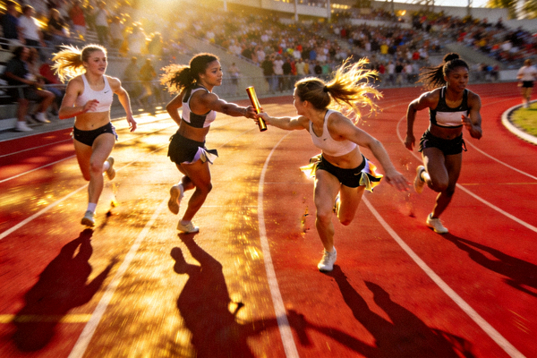女子4x100米接力交接棒精彩配合，队员伸手递棒