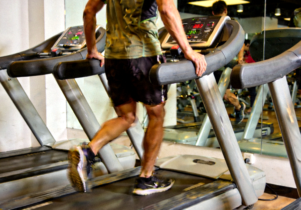 健身者在健身房跑步机上进行有氧训练的场景