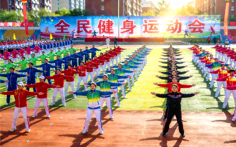 群众在体育场参加全民健身运动会集体项目的场景
