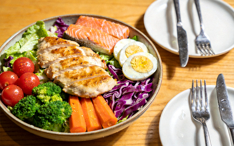 餐桌上摆放的健康营养餐食，包含蔬菜水果与优质蛋白