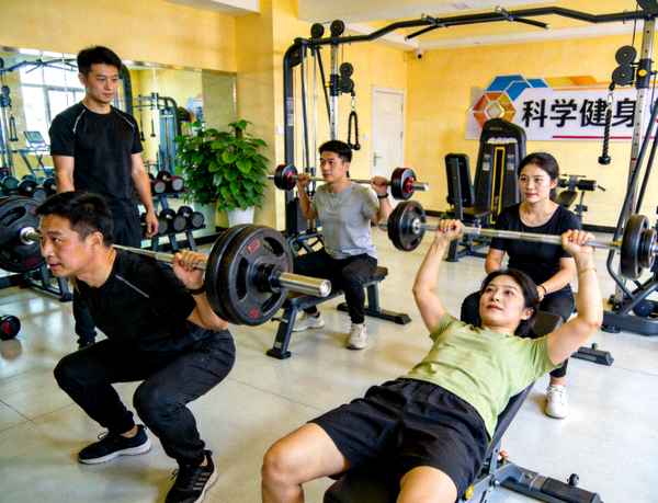 社区健身房里居民使用器械进行力量训练，氛围积极向上