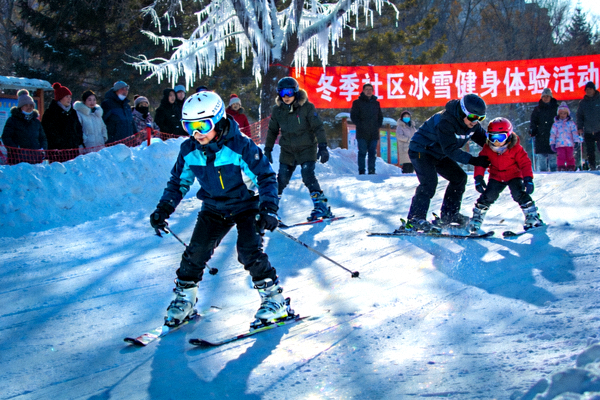 冬季社区冰雪健身体验活动，居民在雪场上体验滑雪运动